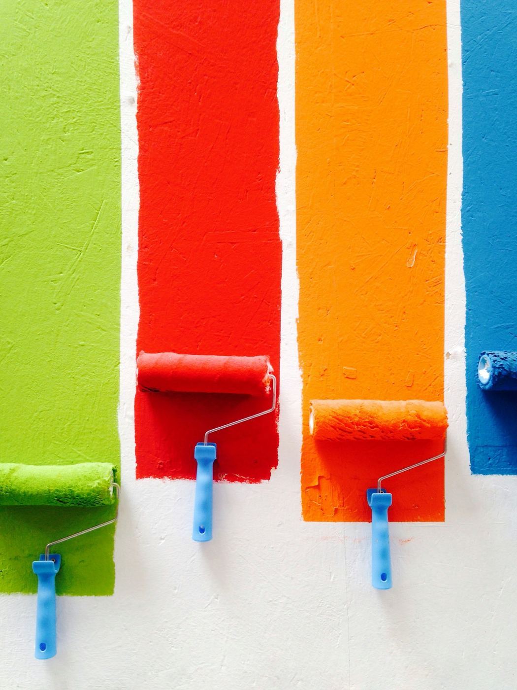 Paint rollers with fresh colour stripes
