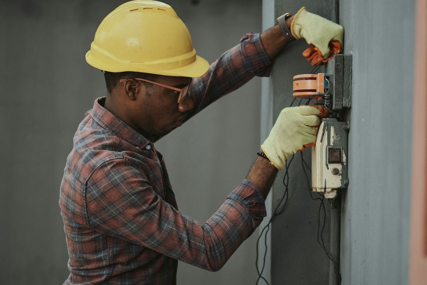 Electrician fixing a wall-mounted electrical unit